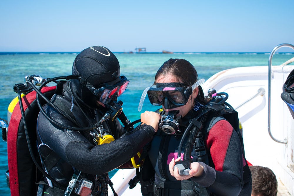 two divers in equipment on a yacht against the background of azure sea. Instruction on immersion.