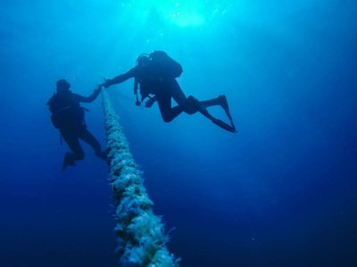 Scuba Divers Descending Holding a Rope to a Shipwreck in the Red Sea in Egypt